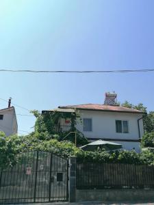 a white house with a gate and an umbrella at Vila Didi, Mangalia in Mangalia