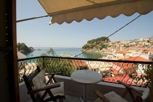 een balkon met uitzicht op de stad en de oceaan bij Olympic Apartments in Parga