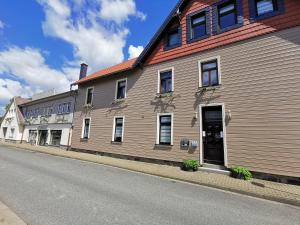 ein großes Holzgebäude an der Straßenseite in der Unterkunft Altstadt Pension Orchidee in Wernigerode