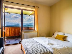 a bedroom with a bed and a large window at Willa Majerczyk in Poronin