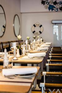 une rangée de tables avec des serviettes blanches et des miroirs dans l'établissement Star-Apart Hansa Hotel, à Wiesbaden