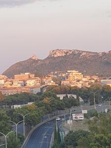 uma estrada numa cidade com uma montanha ao fundo em Nuovo attico con terrazza 5 minuti dal mare em Cagliari