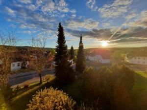 um pôr-do-sol sobre uma aldeia com árvores e uma estrada em Ferienwohnung sunset Weissenstadt em Weißenstadt