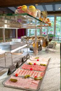 a buffet with meat and vegetables on a table at Hotel Arca Solebad & Spa in Zermatt