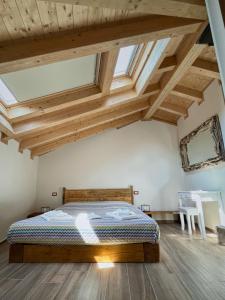 um quarto com uma cama num quarto com tectos em madeira em Ca de Sora em Luino