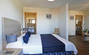 - une chambre avec un grand lit et des oreillers bleus dans l'établissement Hôtel Funtana Marina, à LʼÎle-Rousse