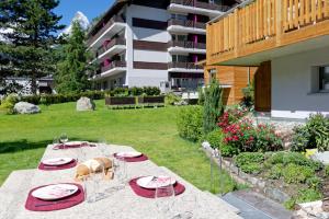 a table with plates and glasses in a yard at Hotel Arca Solebad & Spa in Zermatt