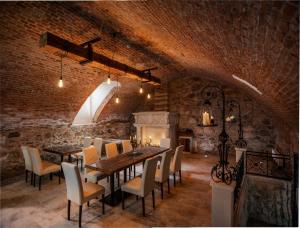 comedor con mesa, sillas y chimenea en Florand Rooms&Wine, en Sopron