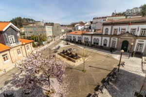 Casa do Paço في ترمس دي ساو بيدرو دو سول: شارع المدينة فيه مباني وشجرة فيها ورد ارجواني