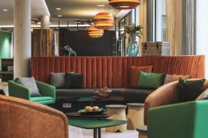 una hall con divano, tavoli e sedie di Holiday Inn - the niu, Hop Forchheim, an IHG Hotel a Forchheim