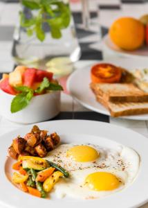 un plato de comida con huevos y verduras en una mesa en Sapphire Boutique Hotel, en Thane