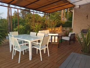 a white table and chairs on a wooden deck at Chambre d hôtes de la Louve in Fréjus