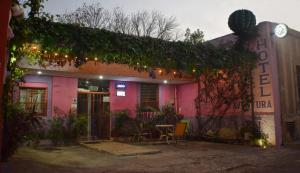 a pink building with a table in front of it at Hotel Aventura in Mérida