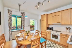 een keuken en eetkamer met een houten tafel en stoelen bij Payerbach Apartments in Payerbach