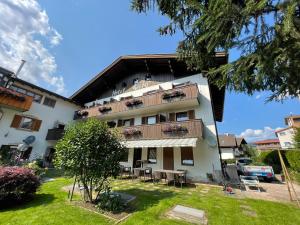 a building with a balcony with tables and chairs at Hotel Garni Savoy in Castelrotto