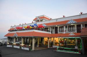 - un restaurant avec des personnes sur le balcon dans l'établissement Hotel Apple Valley, à Kodaikānāl