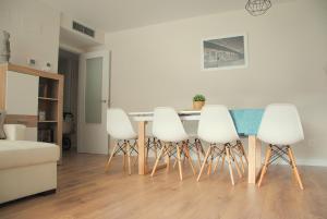 a dining room with a table and white chairs at Apartamento Dulcinea in Alcalá de Henares