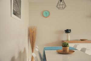 a dining room with a table and a clock on the wall at Apartamento Dulcinea in Alcalá de Henares