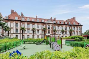 een speeltuin voor een groot gebouw bij Résidence Pierre & Vacances Premium Presqu'Ile de la Touques in Deauville