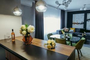 uma sala de estar com uma mesa com flores em Charlotte Apartment - 2Bedrooms w Parking near Nymphaea em Oradea