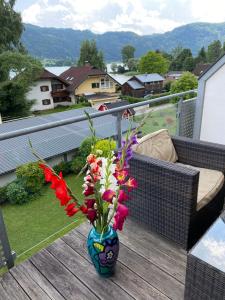 a vase with flowers in it on a balcony at FeWo mit Seeblick in Bodensdorf