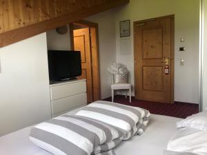 - une chambre avec un lit, une télévision et une porte dans l'établissement Hotel Rosslaufhof, à Castelrotto