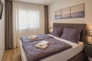 Deluxe Apartment Graz في غراتس: غرفة نوم عليها سرير وفوط