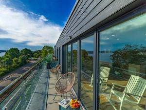 Un balcón con sillas y un bol de fruta en una mesa. en Villa Beachside, en Eckernförde