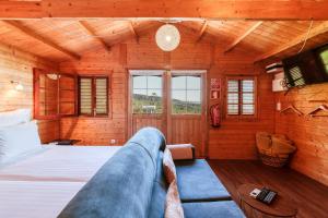 ein Schlafzimmer mit einem Bett in einem Holzzimmer in der Unterkunft Madeira Sunset Cottage - Nature Retreat in Ponta do Pargo