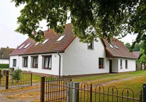 een wit huis met een rood dak bij schoene Ferienwohnung mit Terrasse in Ralswiek