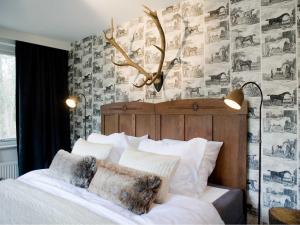 - une chambre dotée d'un lit blanc avec un bois sur le mur dans l'établissement Hotel & Restaurant Meneer Van Eijck, à Oisterwijk