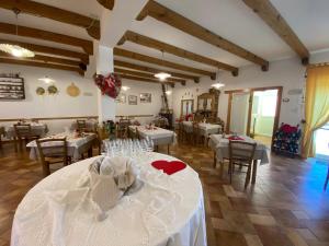 een eetkamer met tafels met witte tafelkleden bij Al Castello in Artegna