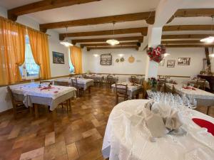 een eetkamer met tafels met witte tafelkleden bij Al Castello in Artegna