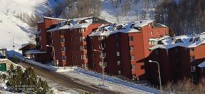 un edificio con techos nevados en una montaña en TANA DELLA MARMOTTA - renovated, ski in ski out, turkish bath, garage, storage, en Breuil-Cervinia