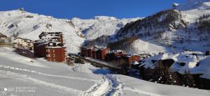 una ciudad en la nieve con una montaña en el fondo en TANA DELLA MARMOTTA - renovated, ski in ski out, turkish bath, garage, storage, en Breuil-Cervinia