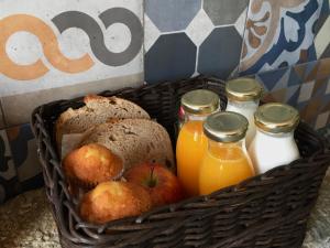 a basket filled with bread and bottles of orange juice at Jardines Villaverde in Villaverde de Pontones