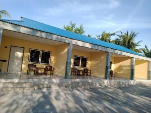 une petite maison jaune avec un toit bleu dans l'établissement Hotel Wailiti, à Maumere