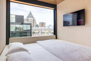 een slaapkamer met een bed en een groot raam bij citizenM Rotterdam in Rotterdam