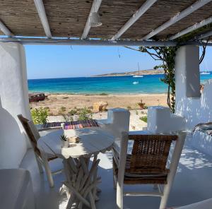 een tafel en stoelen met uitzicht op het strand bij Palio Karnagio Παλιό Καρνάγιο in Koufonisia