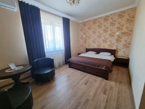 Schlafzimmer mit einem Bett, einem Schreibtisch und einem Stuhl in der Unterkunft НИК аэро in Kharkov