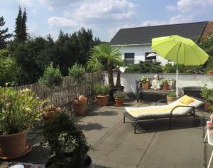 a patio with a chair and an umbrella and plants at Beletage in Neuwied