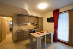 a kitchen with a table in the middle of a room at Residence Ables in Valfurva