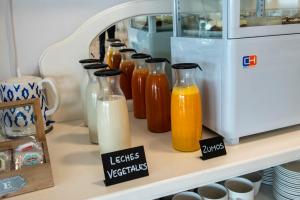 eine Reihe von Flaschen Milch und Orangensaft auf einem Regal in der Unterkunft Hotel Faro de San Vicente in San Vicente de la Barquera