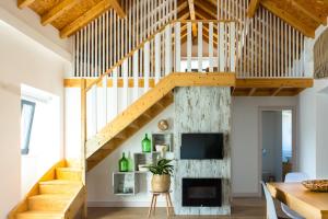 a wooden staircase in a living room with a fireplace at Casa Marmelos - Alojamento Local in Ourém