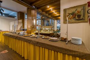 een lange tafel met borden eten erop bij Hotel Villa Argentina in Cortina dʼAmpezzo