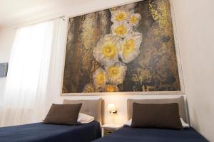 um quarto com duas camas e um quadro na parede em B&B 7 Rooms em Pisa