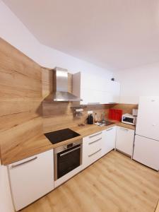 a kitchen with white cabinets and wooden counter tops at Apartment House Kamzik 26 in Donovaly