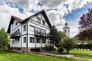 uma casa branca com um campanário e uma igreja em Pensiunea Muntele Rece em Bran