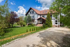 uma grande casa branca com uma entrada em Pensiunea Muntele Rece em Bran