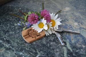 un bouquet de fleurs avec un cœur sur une clé en bois dans l'établissement Appartement Wieshof, à Neukirchen am Großvenediger